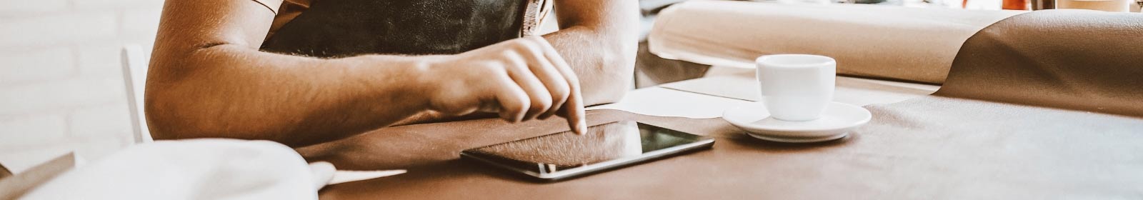 Person having coffee and using a tablet.