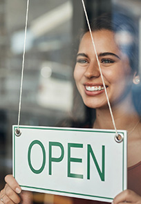 Business owner holding an open sign.
