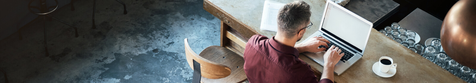 Person at a laptop drinking coffee.